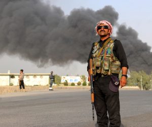 epa07725348 Afghan security officials rush to the scene as smoke rises at the scene of a car bomb blast that targeted the Police headquarters, in Kandahar, Afghanistan, 18 July 2019. At least 12 people were killed and several others injured in the incident.  EPA/STRINGER
