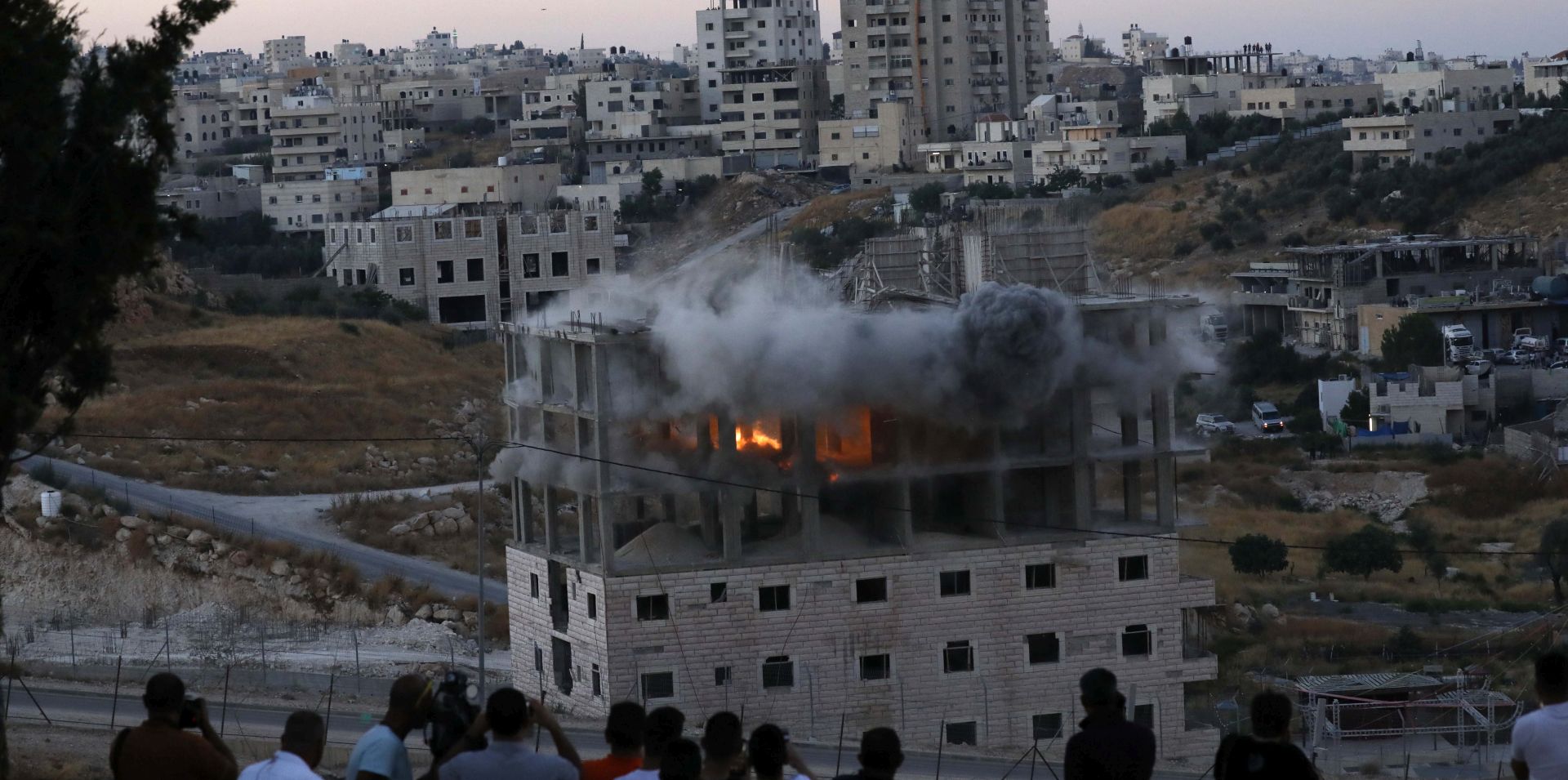 epa07733954 A Palestinian building is blown up by Israeli forces in the village of Sur Baher which sits on both sides of the Israeli barrier in East Jerusalem and the Israeli-occupied West Bank, 22 July 2019. Israeli authorities decided to demolish at least six Palestinian residential buildings housing lots of Palestinian families. The Israeli military announced the buildings were close to the West Bank separation barrier.  EPA/ABED AL HASHLAMOUN