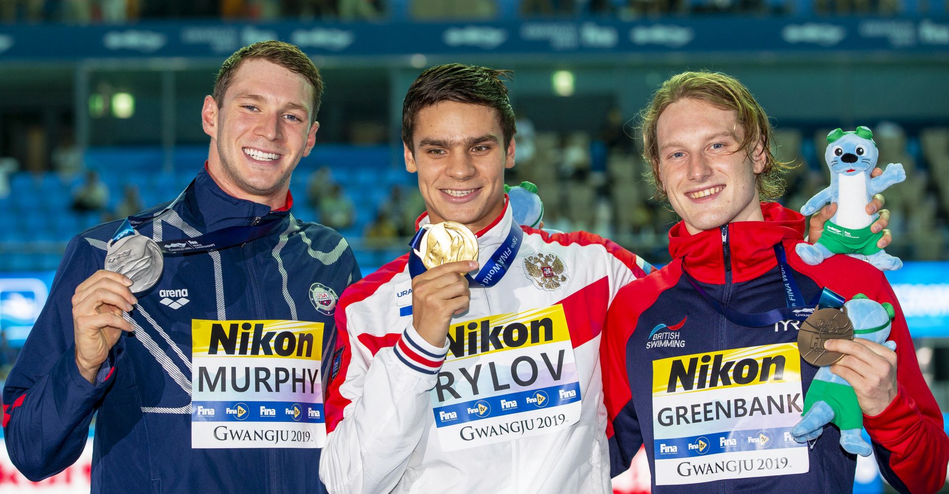 epa07742134 (L-R) Second placed Ryan Murphy of the USA, winner Evgeny Rylov of Russia, and third placed Luke Greenbank of Britain pose with their medals after the medal ceremony for the men's 200m Backstroke final during the Swimming events at the Gwangju 2019 FINA World Championships in Gwangju, South Korea, 26 July 2019.  EPA/PATRICK B. KRAEMER