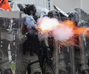 epa07743718 Riot police fire tear gas during a mass rally in Yuen Long, New Territories, Hong Kong, China, 27 July 2019. Anti-extradition bill protesters took to the streets to denounce the break out of violence on 21 July when more than 100 white-clad men suspected of being triads members beat up travellers in the Yuen Long MTR station. Some of whose victims had come from a march against the government’s now-suspended extradition bill.  EPA/RITCHIE B. TONGO