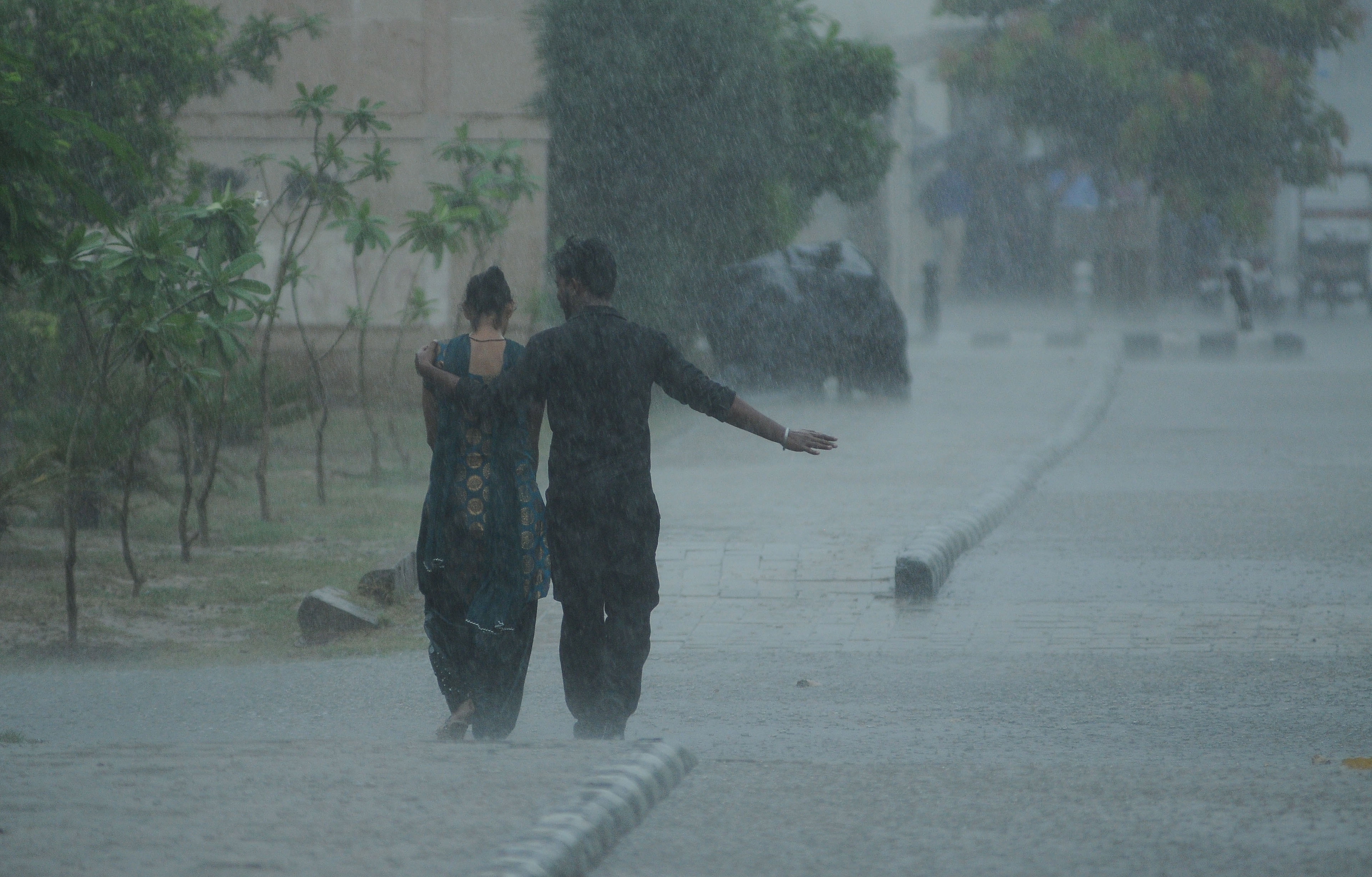 epa07719058 A couple walks amid monsoon rain, in New Delhi, India, 15 July 2019. According to media reports, More than three million people have been affected by floods and displaced across eastern India amid heavy rains, triggered landslides and flooding that has cost lives and destroyed homes  EPA/STR