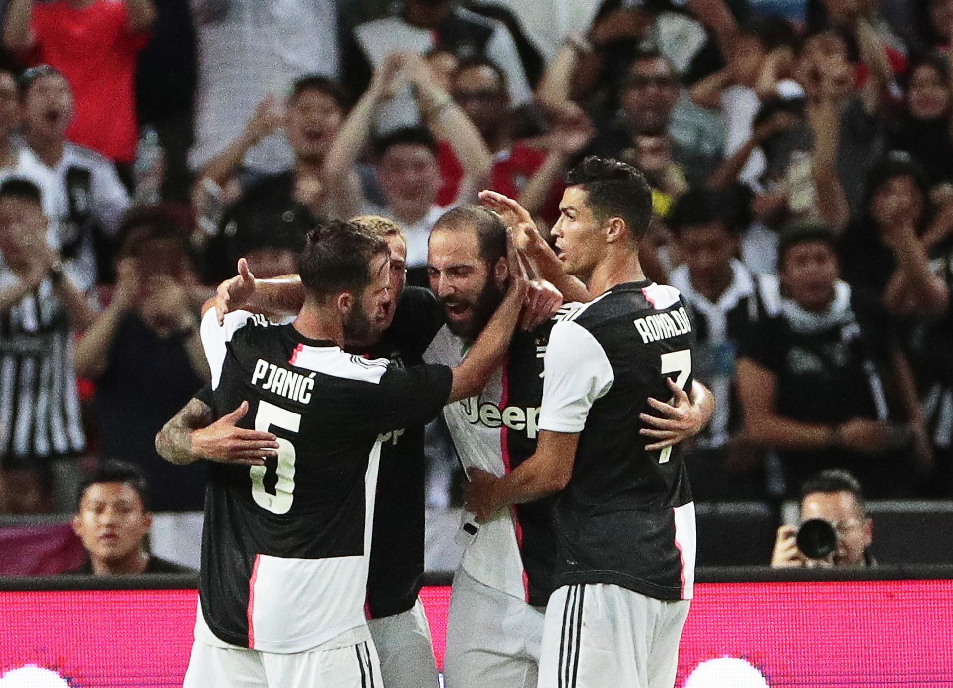 epa07731634 Juventus' Gonzalo Higuain (C) celebrates with his teammates Miralem Pjanic (L) and Cristiano Ronaldo (R) after scoring the 1-1 equalizer during the International Champions Cup (ICC) soccer match between Juventus FC and Tottenham Hotspur at the National Stadium in Singapore, 21 July 2019.  EPA/WALLACE WOON