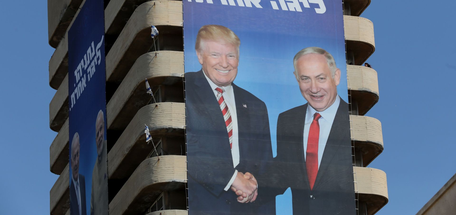 epa07750144 An election campaign billboard of the ruling Likud party shows  Israeli Prime Minister Benjamin Netanyahu (R) shakes hands with US President Donald Trump (L) in Metzudat Ze'ev, the headquarters of the Likud party in Tel Aviv, Israel, 31 July 2019. Israel's legislative elections is scheduled for 17 September 2019.  EPA/ABIR SULTAN