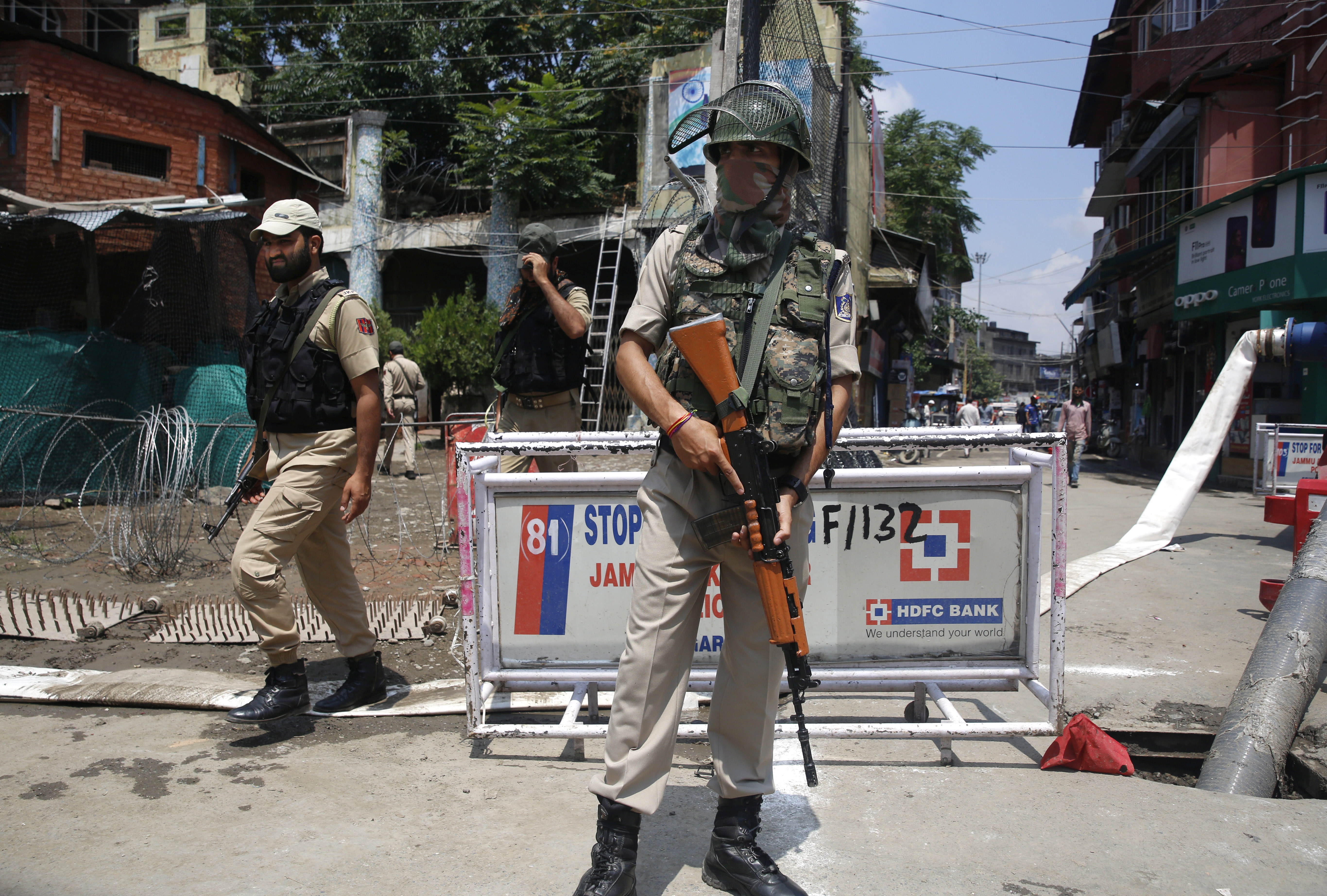 epa07753104 An Indian paramilitary soldier stands guard as policemen walk past in Srinagar, the summer capital of Indian Kashmir, 02 August 2019. According to local news reports over 280 companies of paramilitary forces are being deployed in the Kashmir valley.  EPA/FAROOQ KHAN
