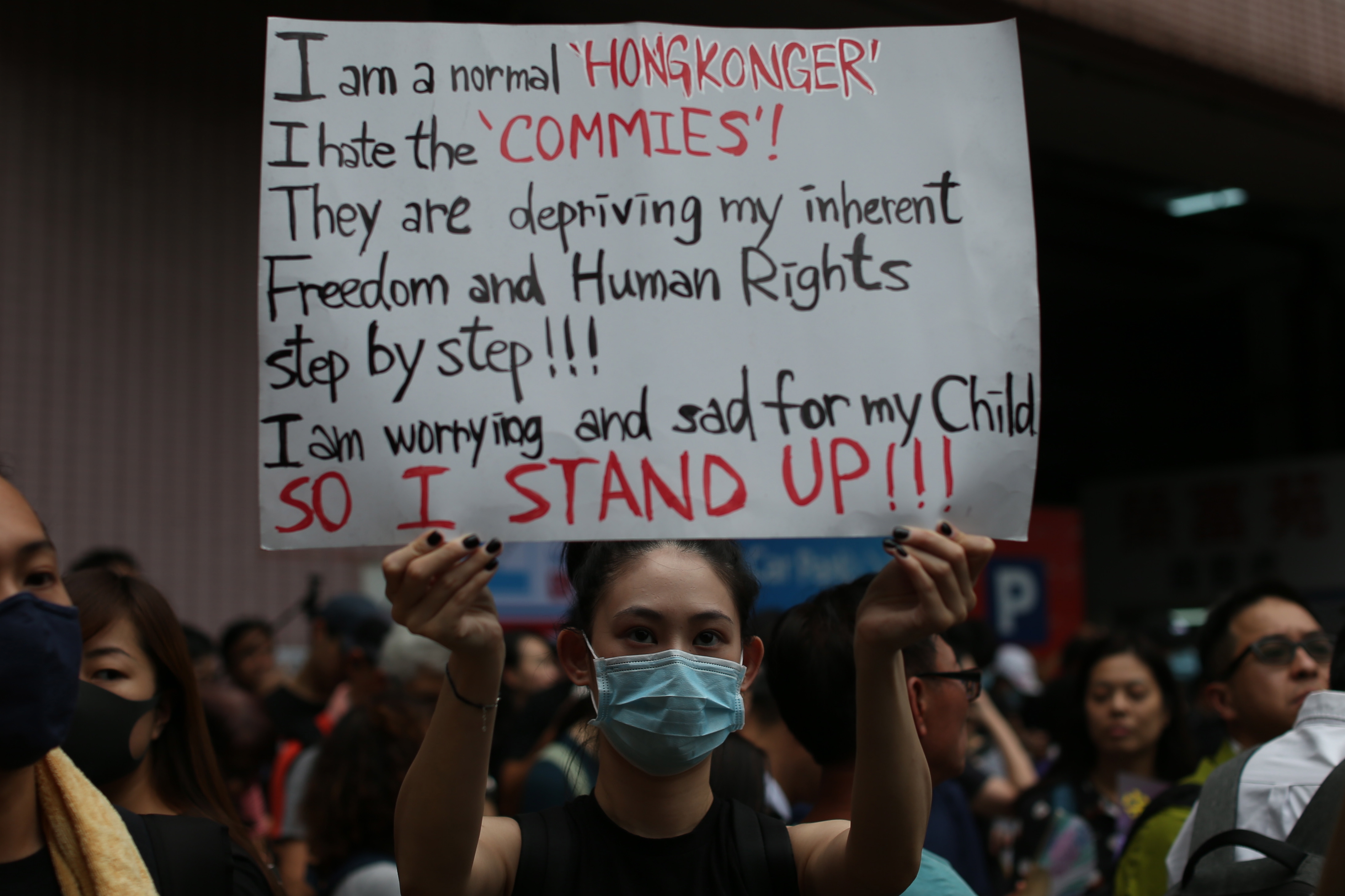 epa07754473 An anti-extradition bill protester holds a banner as she a rally in Mongkok district, Hong Kong, China, 03 August 2019. Hong Kong is bracing itself for a ninth consecutive weekend of multiple anti-extradition demonstrations and a planned citywide strike on 05 August.  EPA/JEROME FAVRE