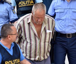 epa07754729 (FILE) - Romanian police officers escort the alleged suspect (C) at Dolj county court, Romania, 27 July 2018, reissued 03 August 2019, after the man was accused of kidnapping a 15 year old girl, who is now confirmed by forensics to have been killed, in the southern city of Caracal, Romania. Alexandra a 15-year-old girl, disappeared on 25 July 2019 hitchhiking to Caracal. Media reports on 28 July 2019 that despite making three emergency calls telling police where she was being held and she had been abducted by a car driver Alexandra's calls went unheeded. Romanian police did not search the property until 19 hours after the girl's last call finding human remains and jewellery. Today, the DIICOT (Directorate for the Investigation of Organized Crime and Terrorism)prosecutors make public the fact that forensic biological evidence taken from the suspect's home matched Alexandra's DNA, announcing her relatives last night.  EPA/BOGDAN DANSECU ROMANIA OUT