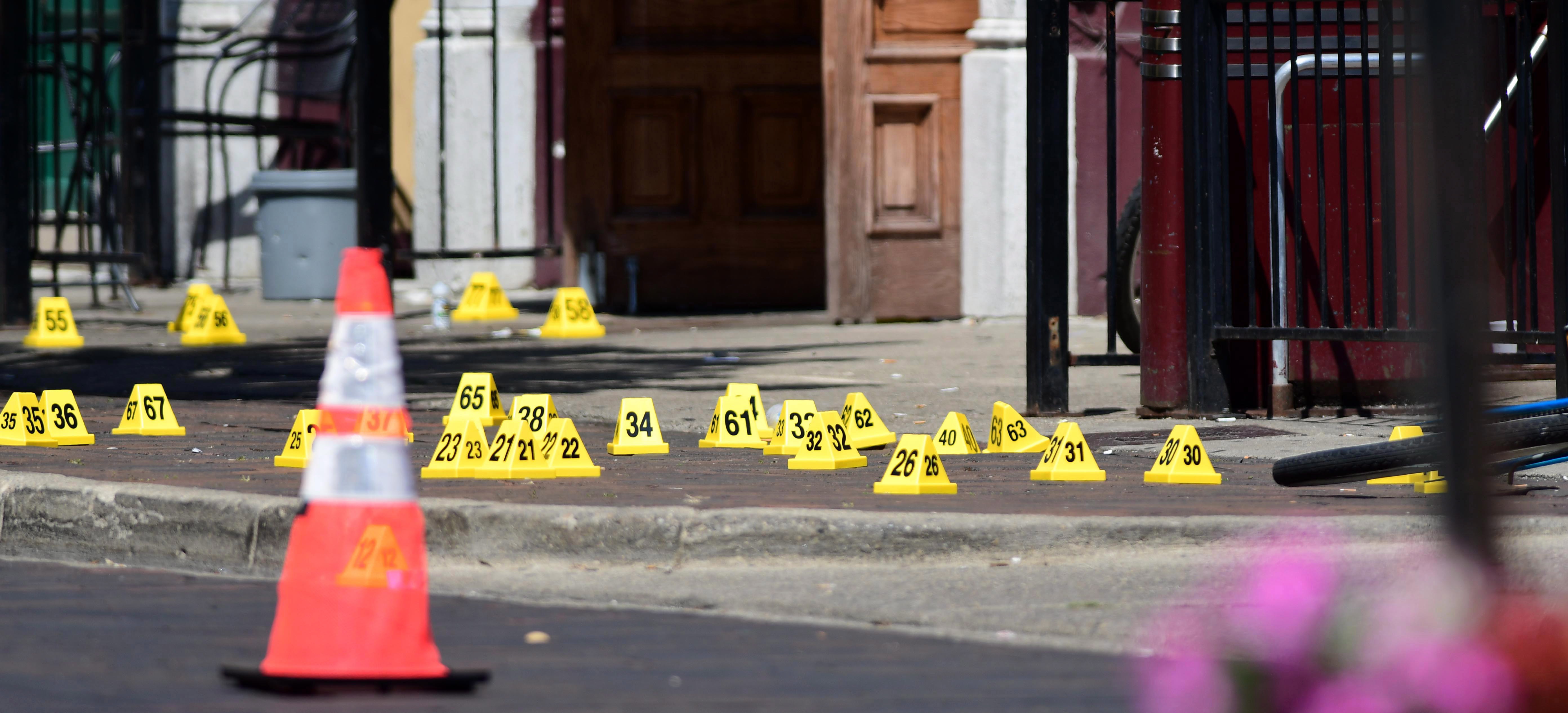 epa07756793 Evidence markers of shell casings line the street at the scene of a shooting in the Oregon District of Dayton, Ohio, USA, 04 August 2019. According to preliminary reports from police, nine people were killed and 27 others wounded and are being treated in local hospitals. The shooter was killed by police.  EPA/TOM RUSSO