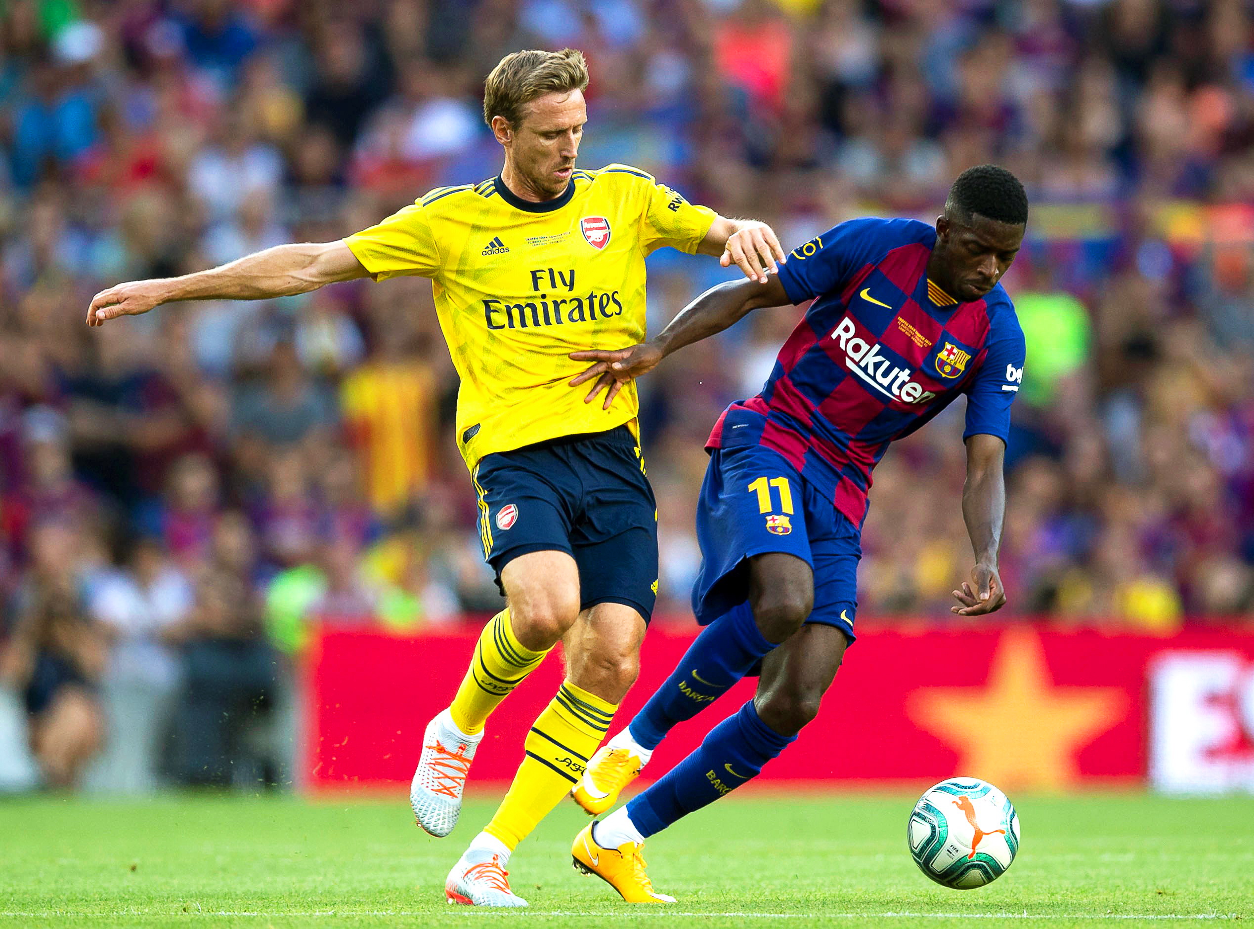 epa07756900 FC Barcelona's Ousmane Dembele (R) in action against Arsenal's Nacho Monreal (L) during the Joan Gamper Trophy soccer match between FC Barcelona and Arsenal FC at Camp Nou in Barcelona, Spain, 04 August 2019.  EPA/ENRIC FONTCUBERTA