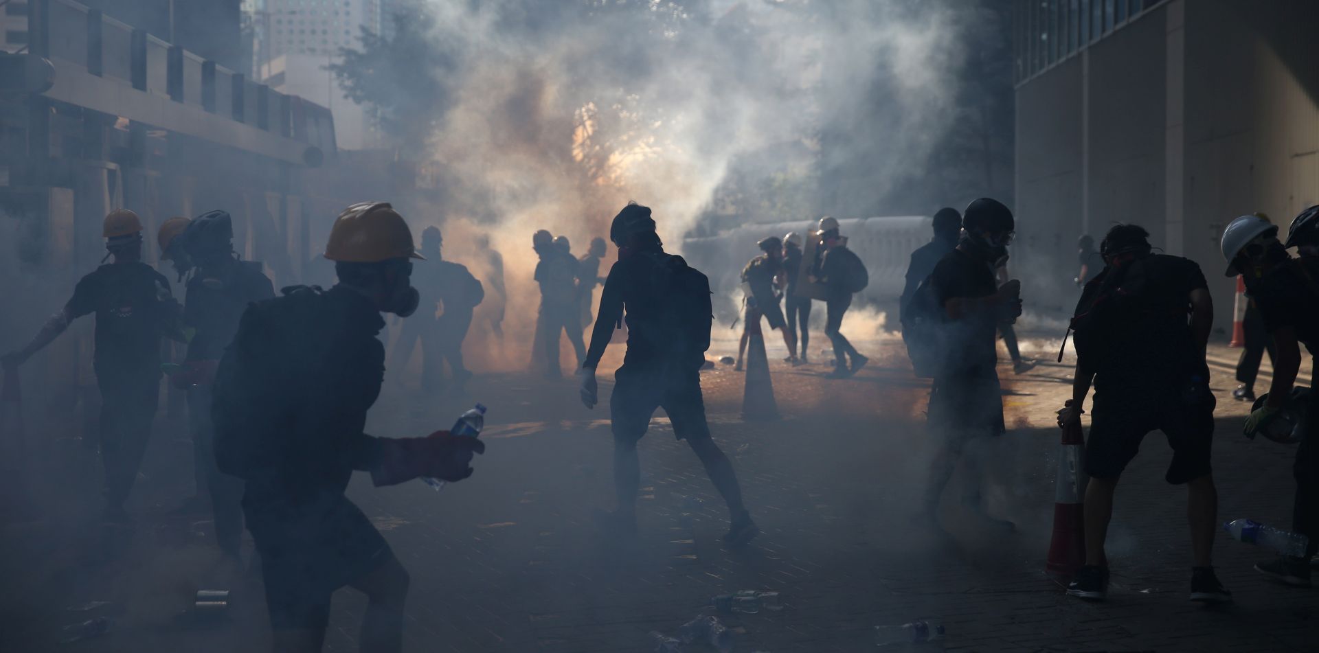 epa07757605 Anti-extradition protesters react after police fired tear gas at them in the Admiralty area of Hong Kong, China, 05 August 2019. Hong Kong is in the midst of a day of citywide strike following a ninth consecutive weekend of multiple anti-extradition rallies and intense clashes between demonstrators and police over the now suspended extradition bill to China.  EPA/JEROME FAVRE