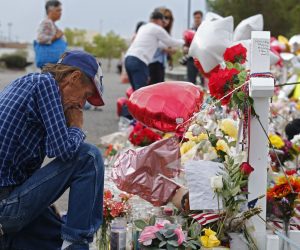 epa07759209 Antonio Basbo kneels in front of the cross for his partner Margie Reckard at the make shift memorial for the mass shooting that happened at a Walmart in El Paso, Texas, USA, 06 August 2019. Twenty two people killed and over forty injured from the mass shooting at the Walmart in El Paso, Texas on 03 August 2019.  EPA/LARRY W. SMITH