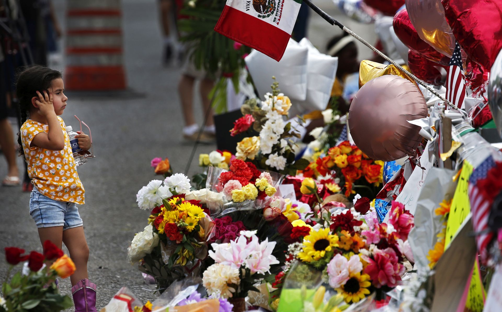 epa07759594 A little girl pauses to look at flowers at the make shift memorial after the mass shooting that happened at a Walmart in El Paso, Texas, 06 August 2019. Twenty two people were killed and 26 injured during a mass shooting at the Walmart on 03 August 2019. Prosecutors said they will seek the death penalty against Patrick Crusius, a 21-year-old man, accused of the mass shooting.  EPA/LARRY W. SMITH