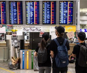 epa07770186 Protesters stand in front of a flight display board showing cancelled flights as they occupy Hong Kong Chek Lap Kok International Airport in Hong Kong, China, 12 August 2019. According to media reports, the Airport Authority said it is virtually shutting down the airport, one of the busiest in the world, as thousands of protesters occupied both the arrival and departure halls of Chek Lap Kok. Hong Kong has been gripped for weeks by mass protests, which began in June 2019 over a now-suspended extradition bill to China and have developed into an anti-government movement.  EPA/LAUREL CHOR