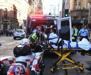 epaselect epa07770604 A woman is taken to an ambulance by paramedics in Sydney, Australia, 13 August 2019. According to media reports a police operation is underway in Sydney's CBD after a person wearing a balaclava stabbed multiple people. Allegedly a man was apprehended in relation to the attacks at Wynyard Station.  EPA/DEAN LEWINS  AUSTRALIA AND NEW ZEALAND OUT