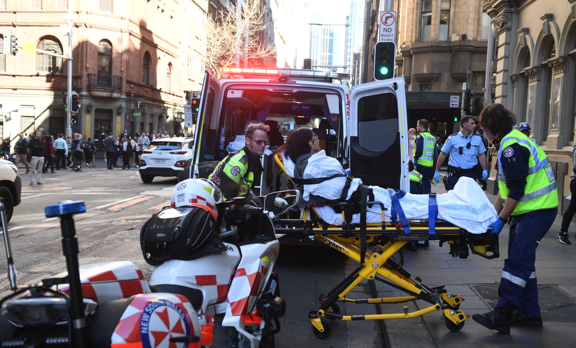 epaselect epa07770604 A woman is taken to an ambulance by paramedics in Sydney, Australia, 13 August 2019. According to media reports a police operation is underway in Sydney's CBD after a person wearing a balaclava stabbed multiple people. Allegedly a man was apprehended in relation to the attacks at Wynyard Station.  EPA/DEAN LEWINS  AUSTRALIA AND NEW ZEALAND OUT
