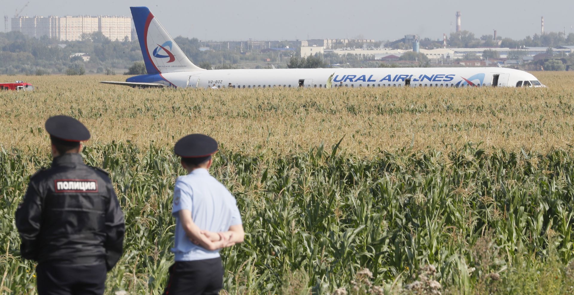 epa07774163 Russian police officers near the site of Ural Airlines A-321 passenger plane emergency landing outside Zhukovsky airport in Ramensky district of Moscow region, Russia, 15 August 2019. A-321 with 226 passengers and seven crew members on board en-route from Moscow to Simferopol made emergency landing after a right engine failure following the plane's colliding with seagulls shortly after take-off. Ten people were hospitalized following the accident.  EPA/SERGEI ILNITSKY