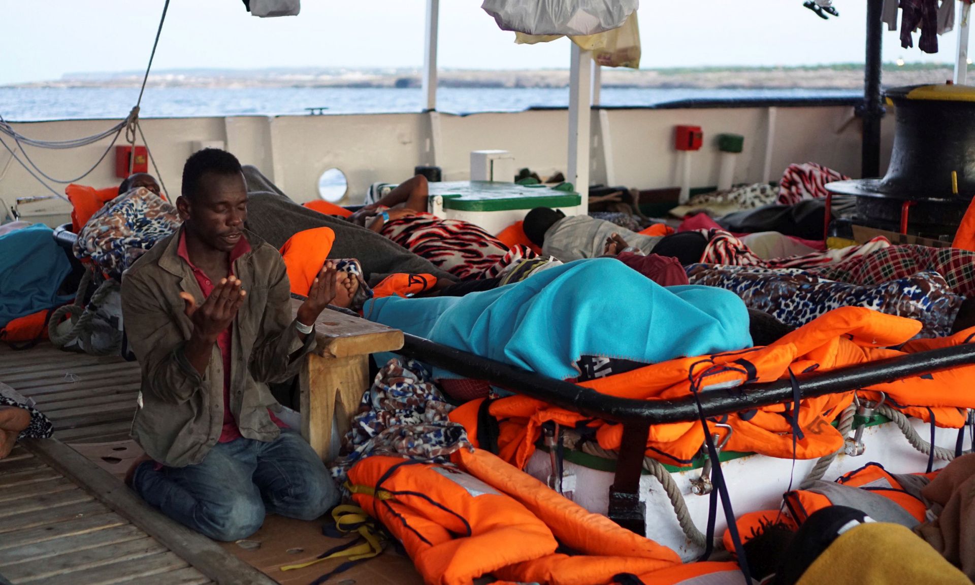 epa07780159 A migrant, one of the 107 on board the Spanish rescue vessel Open Arms, prays during morning hours, off Lampedusa Island, southern Italy, 19 August 2019. Two days after 27 minors and sick migrants were evacuated, the rescue vessel continues stranded off the coast of Italy as it waits to reach a safe port in the Mediterranean sea, despite the Lazio Regional Administrative Court accepted its appeal, suspending the ban on entry into Italian waters ordered by Italian Interior Minister Matteo Salvini.  EPA/FRANCISCO GENTICO