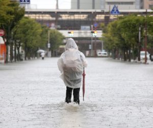 epa07798446 A pedestrian walks in a flooded street near Saga station in Saga, Saga prefecture, southwestern Japan, 28 August 2019. The Japan Meteorological Agency issued emergency heavy rain warnings in the northern part of Kyushu, with maximum level of landslides and flooding.  EPA/JIJI PRESS JAPAN OUT EDITORIAL USE ONLY/  NO ARCHIVES