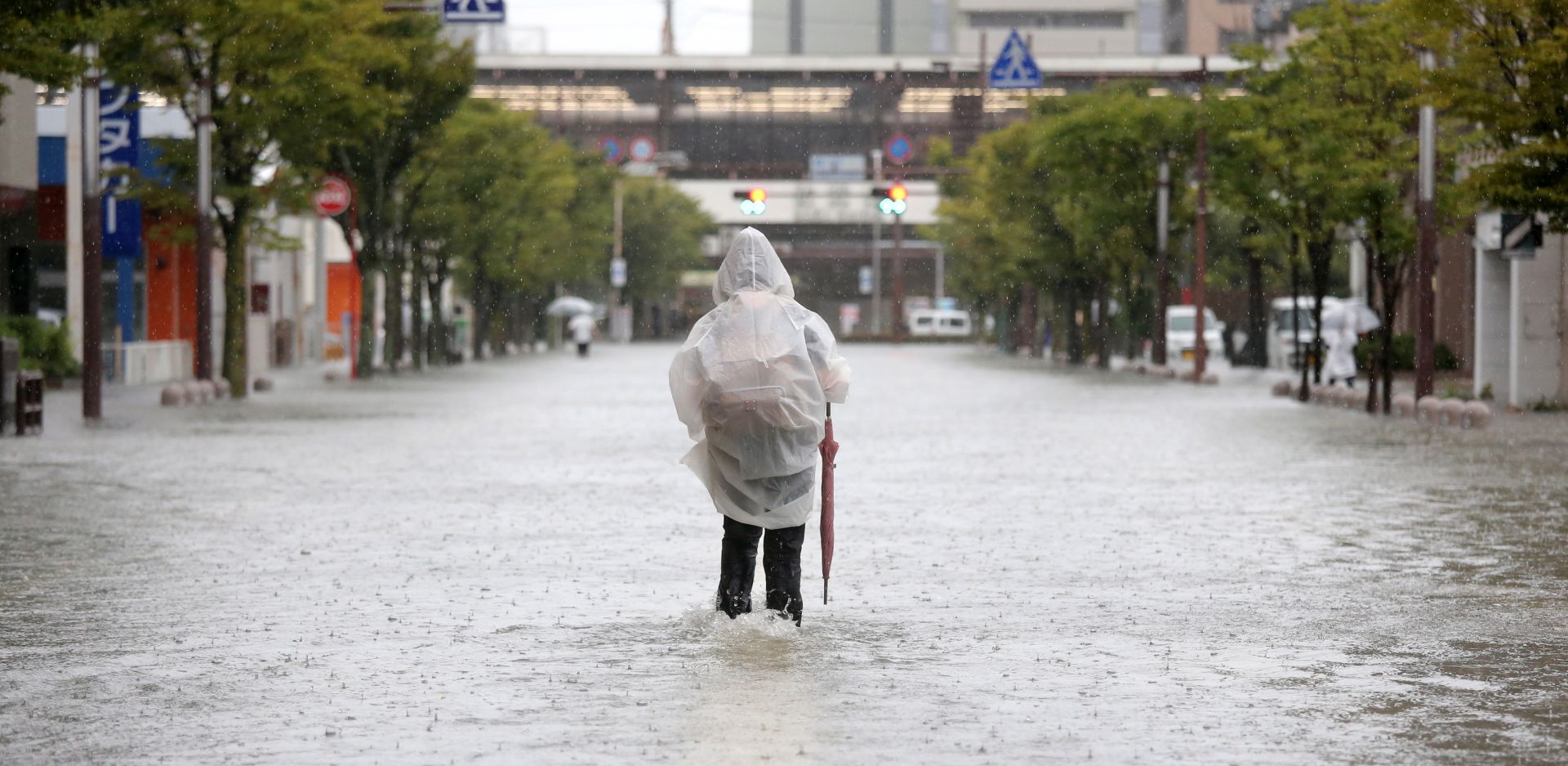epa07798446 A pedestrian walks in a flooded street near Saga station in Saga, Saga prefecture, southwestern Japan, 28 August 2019. The Japan Meteorological Agency issued emergency heavy rain warnings in the northern part of Kyushu, with maximum level of landslides and flooding.  EPA/JIJI PRESS JAPAN OUT EDITORIAL USE ONLY/  NO ARCHIVES