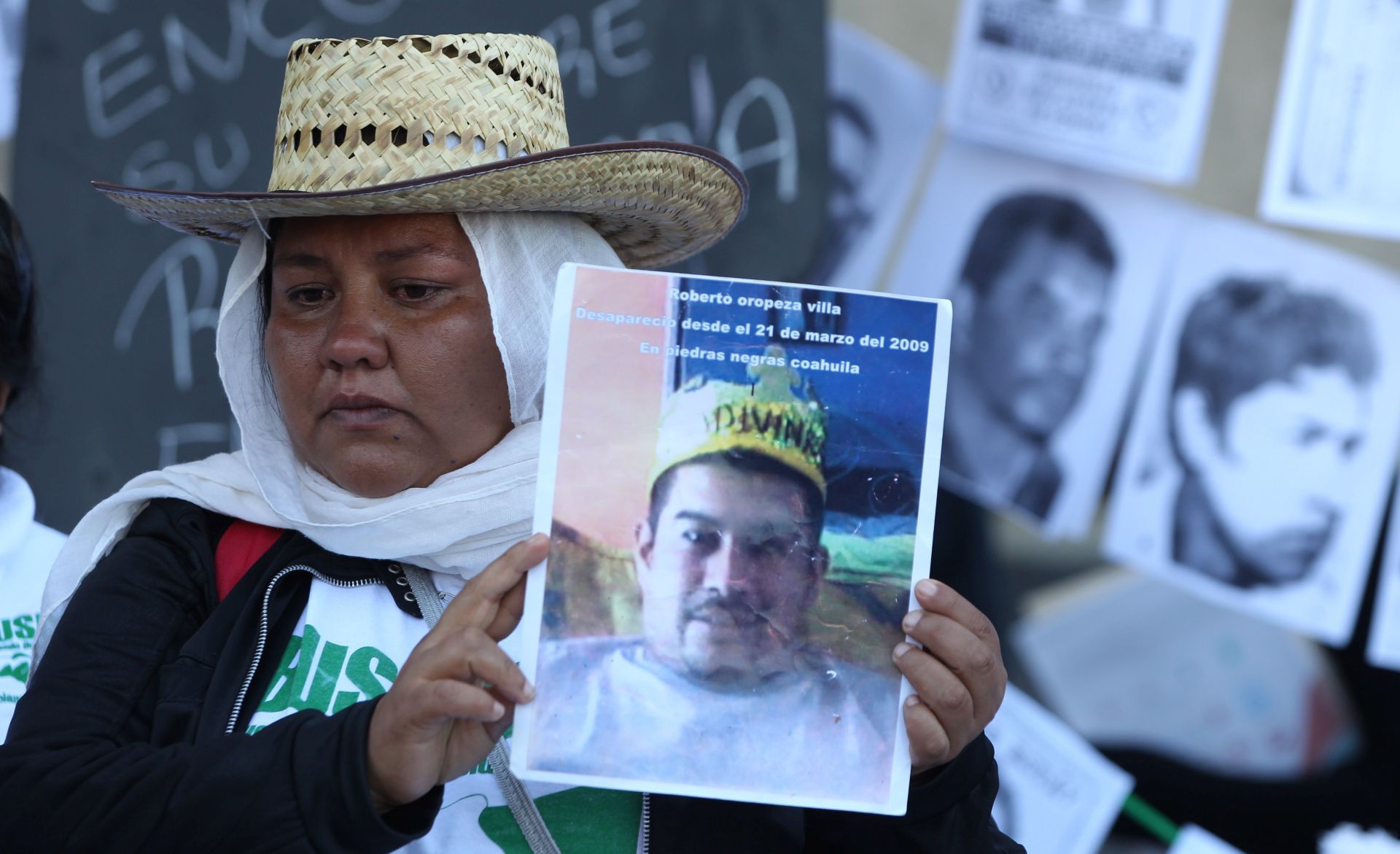 epa07804851 A woman shows a picture of a missing person in front of the National Palace, in Mexico City, Mexico, 30 August 2019.Relatives of missing people also plan to deliver 80.000 signings to demand to the Government better search protocols. At the same time Mexico's President Andres Manuel Lopez Obrador informed that authorities found 4974 bodies in 3024 clandestine graves between 2006 and mid-August 2019.  EPA/Mario Guzmán