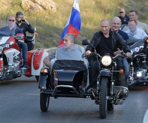 epa07768102 Russian President Vladimir Putin (C) rides an Ural motorbike before the Babylon's Shadow bike show in Sevastopol, Crimea, 10 August 2019. Putin and the Night Wolves bikers took part in an annual show organised by the motorcycle club in the Black Sea peninsula, annexed by Russia from Ukraine in March 2014, while tens of thousands of people on 10 August protested against Putin's government following local election violations.  EPA/ALEXEI DRUZHININ / SPUTNIK / KREMLIN POOL / POOL