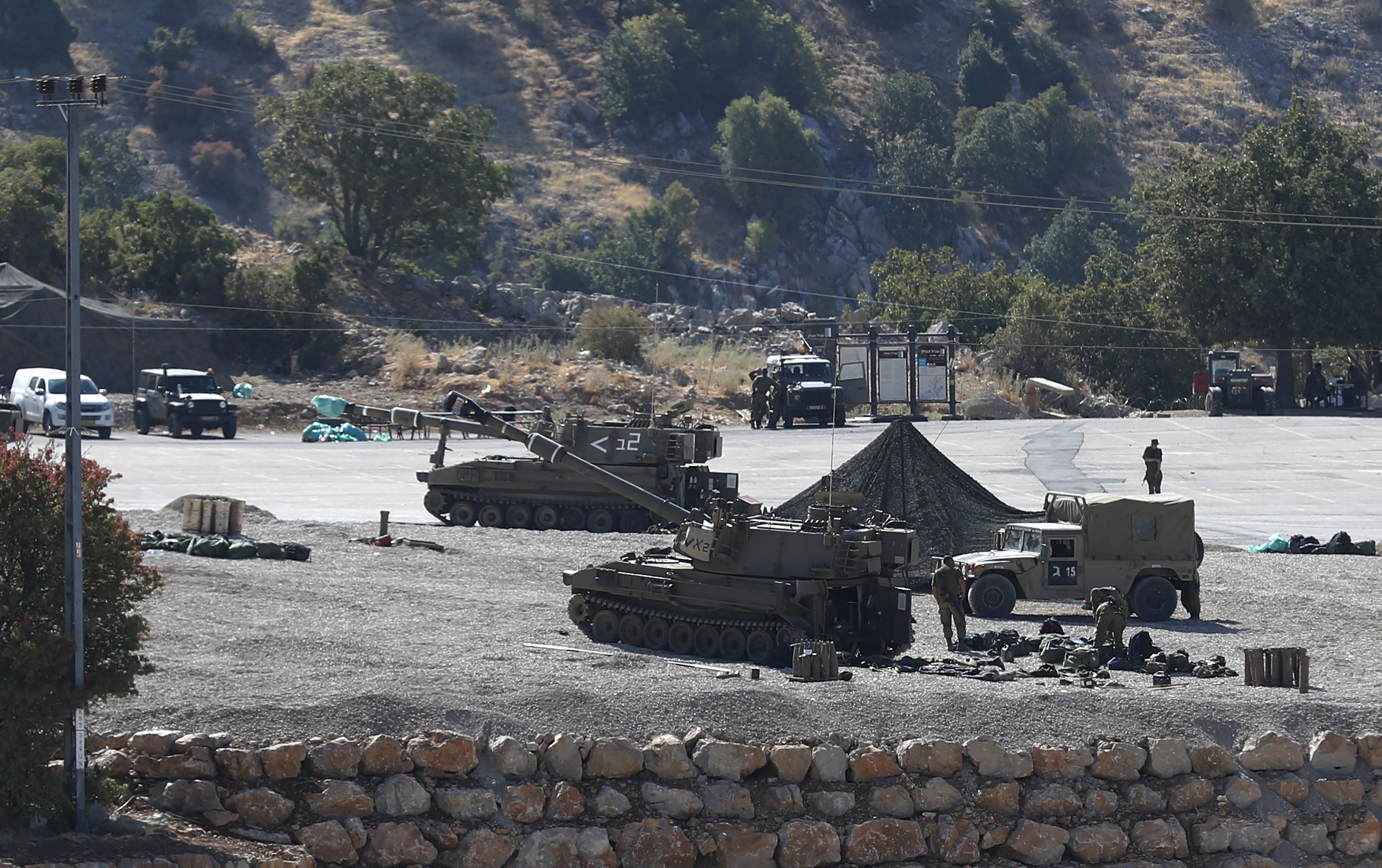 epa07792051 Israeli soldiers with their artillery unit deployed at the Israeli-Syrian border, in the Golan Heights, north of Israel, 25 August 2019. The Israel Defense Forces (IDF) confirmed on the day that overnight its Air Force had struck Iranian Quds Force targets in Syria. In reactions to the incident, the Israeli deployed artillery units and the Iron Dome at the border with Syria.  EPA/ATEF SAFADI