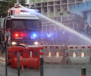 epa07792203 An anti-riot police vehicle equipped with a water cannon clears the road from a barricade set up by protesters during an anti-government rally in Kwai Fung and Tsuen Wan, Hong Kong, China, 25 August 2019. The protests were triggered last June by an extradition bill to China, now suspended, and evolved into a wider anti-government movement with no end in sight.  EPA/JEROME FAVRE