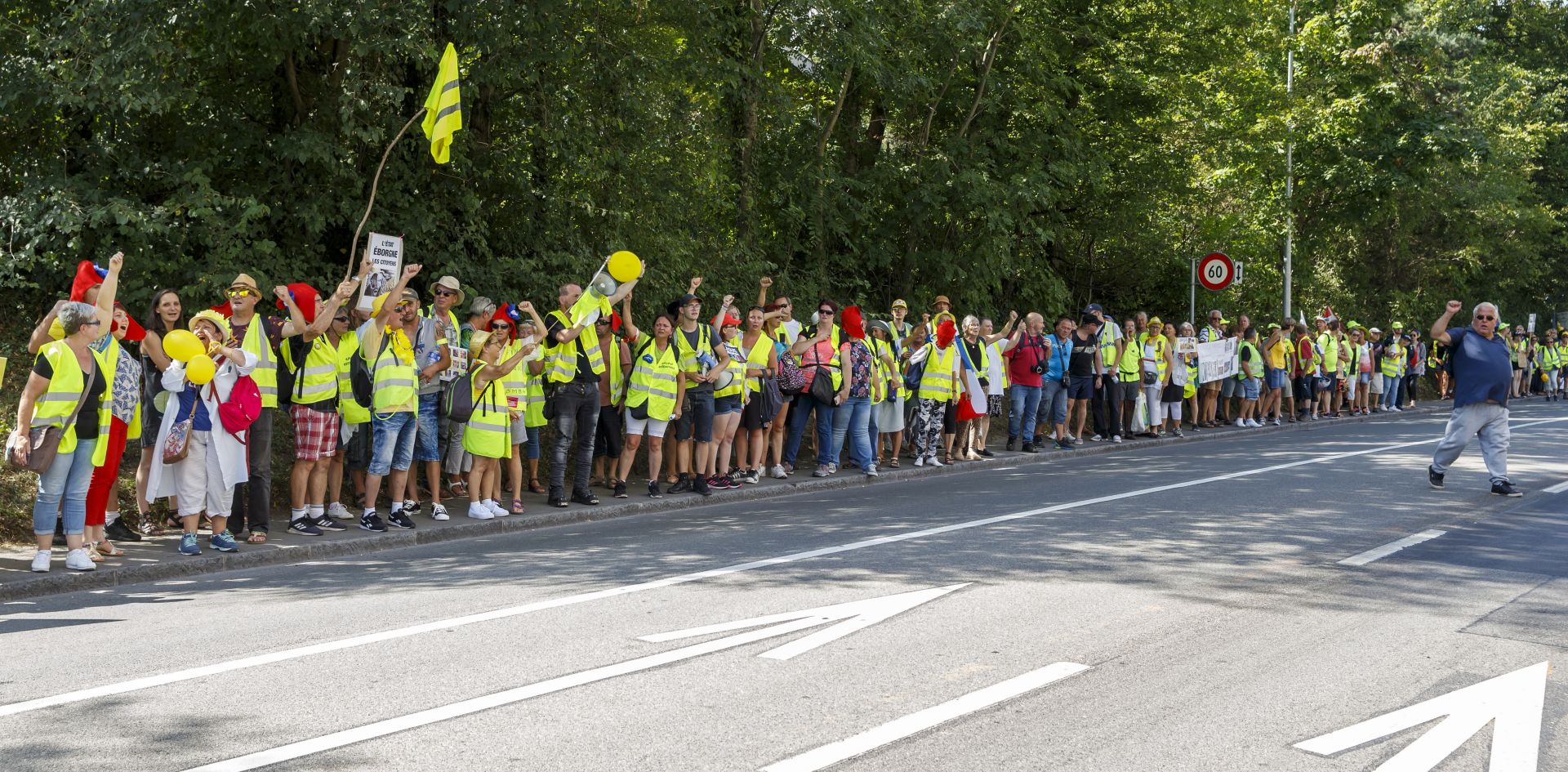 epa07807650 Protesters from the 'Gilets Jaunes' (Yellow Vests) movement hold hands standing on the road during a demonstration, in Geneva, Switzerland, 31 August 2019.  EPA/SALVATORE DI NOLFI