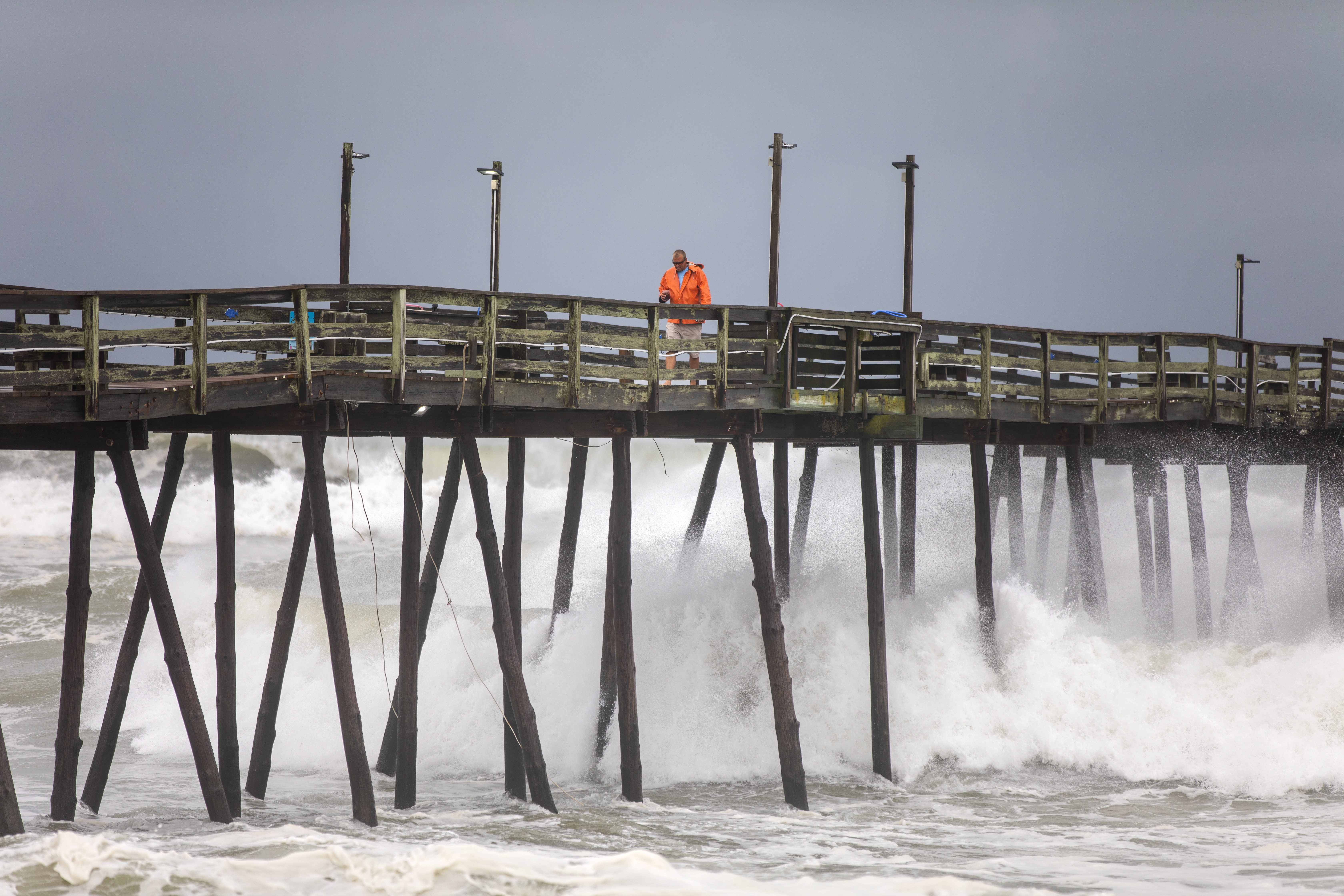 epa07824060 A worker returns after inspecting the Avalon Fishing Pier, which was damaged as Hurricane Dorian struck Kill Devil Hills, North Carolina, USA, 06 September 2019. The Category 1 storm struck the state's fragile barrier islands, the Outer Banks, for much of the day.  EPA/JIM LO SCALZO
