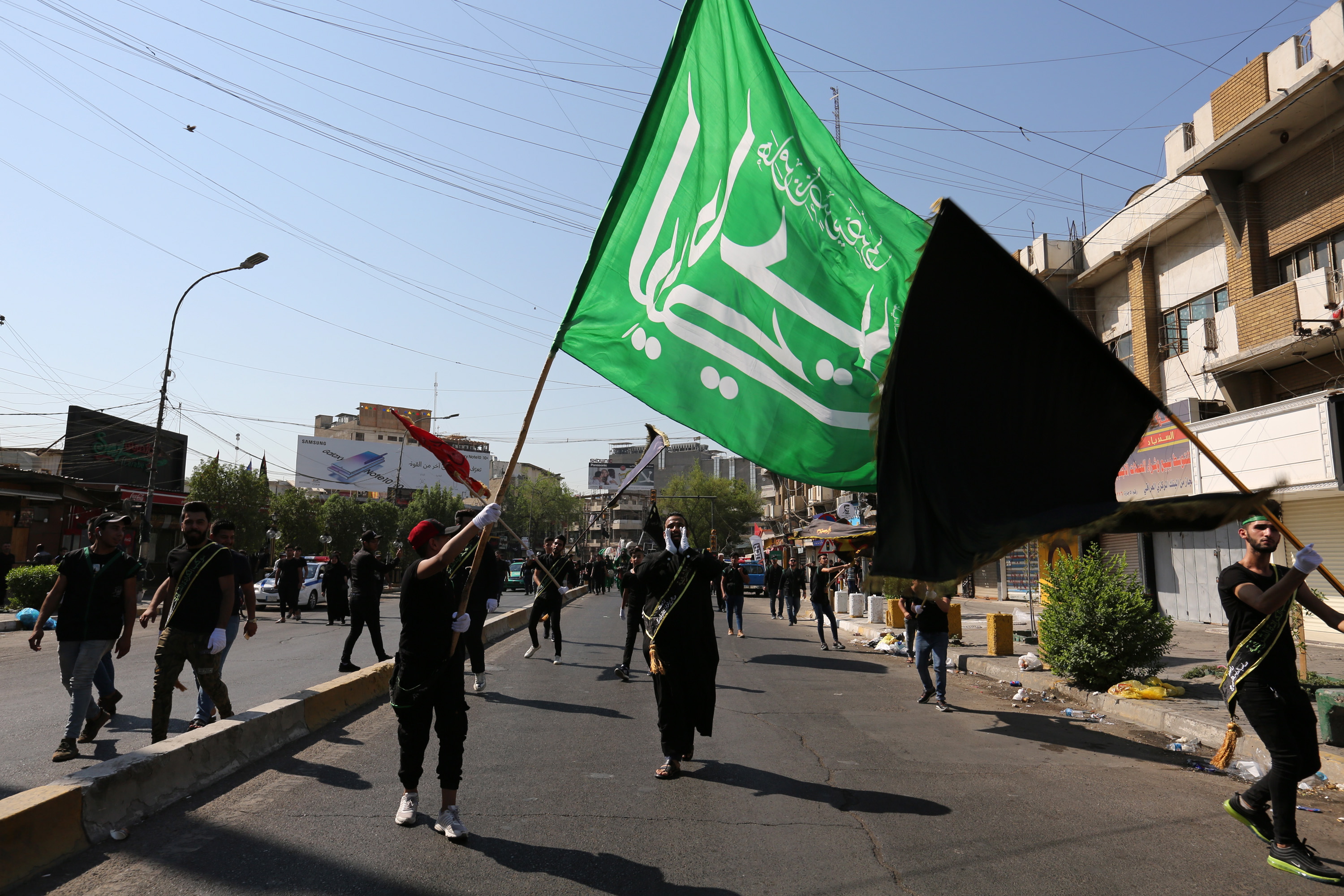 epa07832398 Iraqi Shiite men carry religious flags during the Ashura festivals at Karada district, in central Baghdad, Iraq, 10 September 2019. The Ashura day commemorates the death anniversary of the third Shiite Imam Hussein, who was grandson of Muslim Prophet Muhammed. Ashura is the peak of ten days of mourning when Shiite Muslims mourn the killing of Imam Hussein whose shrine is in Karbala in southern Iraq.  EPA/AHMED JALIL