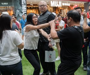 epa07838836 A pro-China supporter (C) scuffles with a pro-Hong Kong supporter (R) during a flash mob event held by China supporters in a shopping mall in Hong Kong, China, 13 September 2019. Recently many shopping malls have witnesed large numbers of pro-China supporters and pro-Hong Kong supporters trying to out-sing and out-shout each other.  EPA/JEROME FAVRE