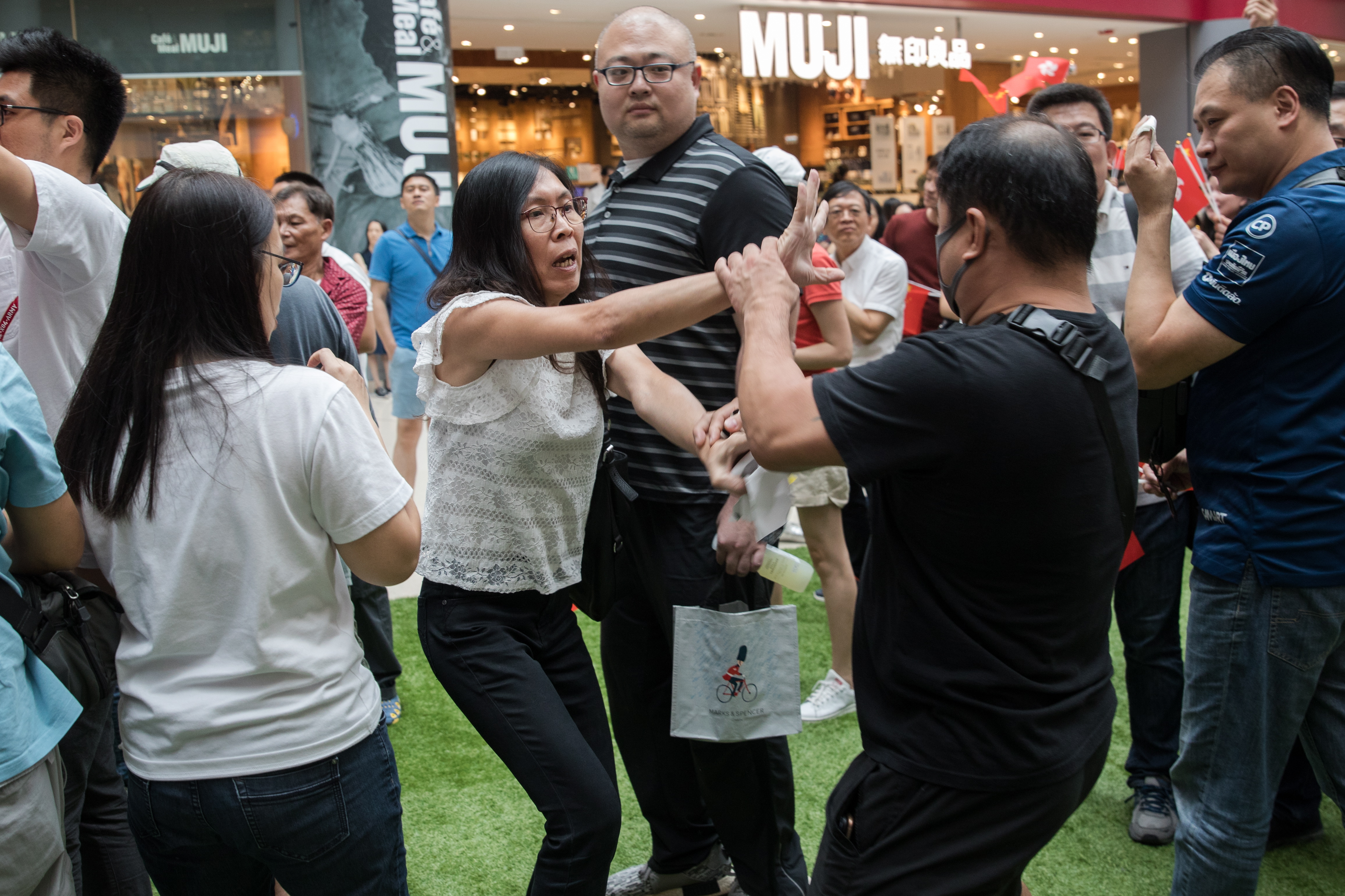 epa07838836 A pro-China supporter (C) scuffles with a pro-Hong Kong supporter (R) during a flash mob event held by China supporters in a shopping mall in Hong Kong, China, 13 September 2019. Recently many shopping malls have witnesed large numbers of pro-China supporters and pro-Hong Kong supporters trying to out-sing and out-shout each other.  EPA/JEROME FAVRE
