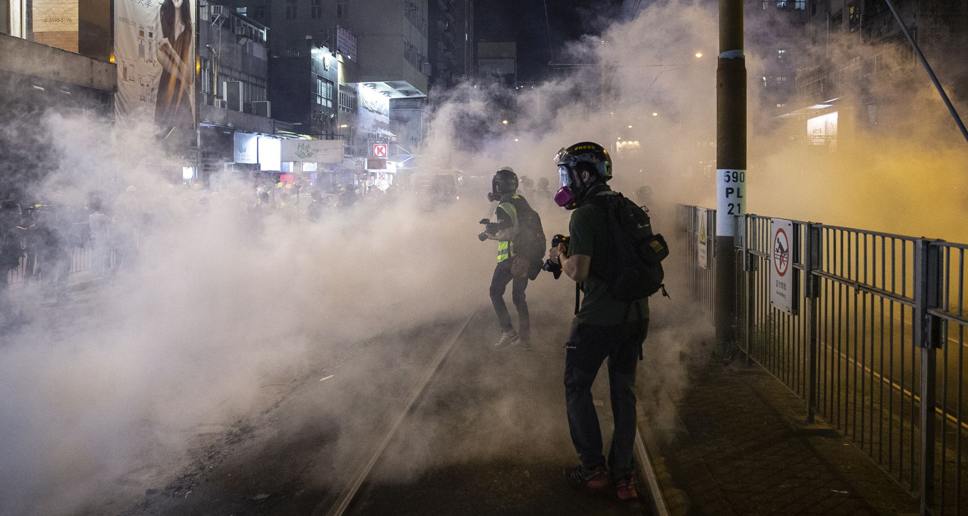 epa07859773 Members of the media photograph tear gas fired by riot police to disperse protesters in Yuen Long district, Hong Kong, China, 21 September 2019. Hong Kong has entered its fourth month of mass protests, originally triggered by a now suspended extradition bill to mainland China that have turned into a wider pro-democracy movement.  EPA/CHAN LONG HEI