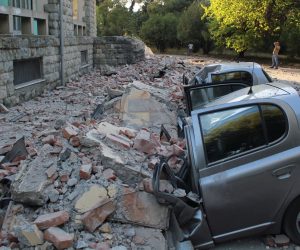 epa07859750 Locals stand at a safe area to watch the damages of crushed cars next to a building of the University of Geology and Mine, after a 5.8 magnitude earthquake hit in Tirana, Albania, 21 September 2019. According to reports, Albania was rocked by its strongest earthquake in 30 years, with the epicentre in the coastal town of Durres, at least 49 people have been reported injured from the earthquake.  EPA/MALTON DIBRA