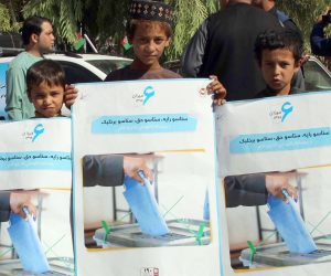 epa07870703 Afghan boys hold posters, featuring the importance of ballot, distributed by the Afghan Independent Election Commission (IEC) on roads ahead of the Presidential elections in Helmand, Afghanistan, 26 September 2019. Presidential elections in Afghanistan are scheduled for 28 September, with a total of 18 candidates, including incumbent President Mohammad Ashraf Ghani, are running for the post.  EPA/WATAN YAR