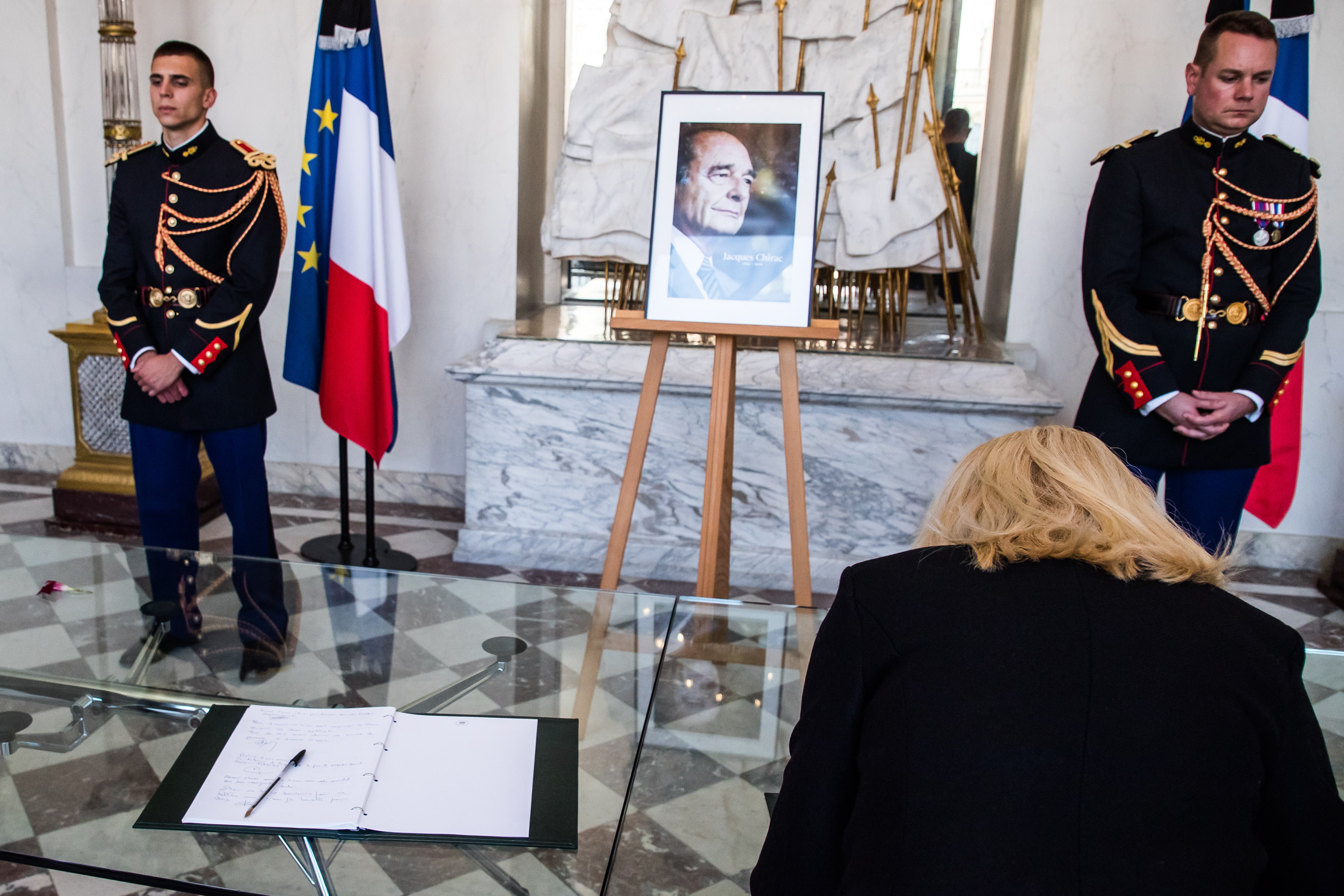 epa07877446 French honor guards stand next to a Jacques Chirac's portrait as people sign condolence registers at the Elysee Presidential Palace, following the death of former French President Jacques Chirac in Paris, France, 28 September 2019. Chirac died peacefully on 26 September 2019 surrounded by his family, aged 86. The former French president Jacques Chirac's health was troubled ever since a 2005 stroke he suffered while still in office. He was head of state from 1995 to 2007, was twice president, twice prime minister and 18 years mayor of Paris.  EPA/CHRISTOPHE PETIT TESSON