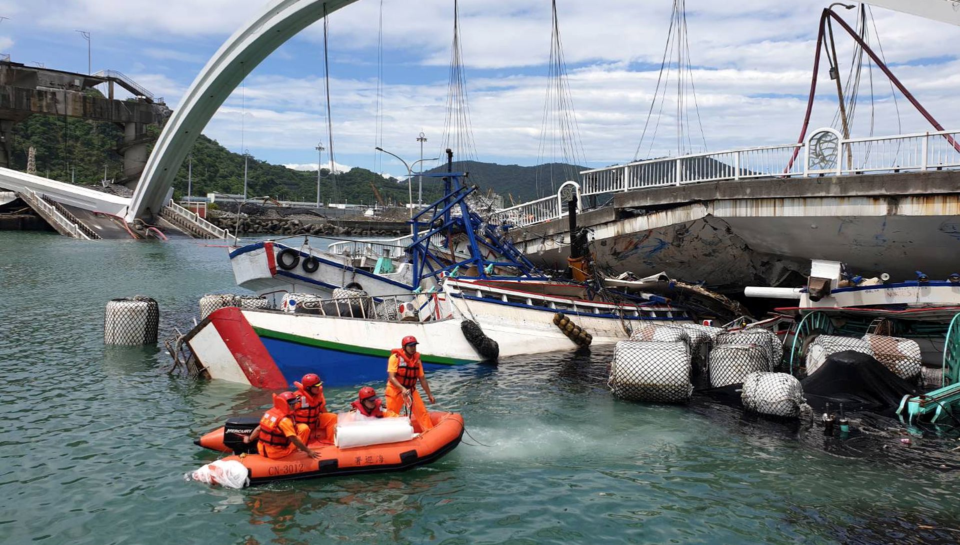 epa07884120 A handout photo made available by Taiwan Coast Guard Administration shows rescuers at the scene of the collapsed Nanfangao Bridge in Nanfangao, Yilan County, northeastern Taiwan, 01 October 2019. According to media reports, the collapse occured soon after an oil tanker crossed on to the bridge. The structural failure caused the tanker to fall into the waterway and ignite. Civilian and military rescuers have rescued 10 people, including oil the tanker's driver.  EPA/TAIWAN COASTGUARD ADMINISTRATION / HANDOUT BEST QUALITY AVAILABLE HANDOUT EDITORIAL USE ONLY/NO SALES