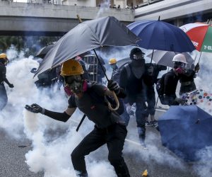 epa07884442 An anti-government protester tosses back a tear gas grenade during protests on National Day in Hong Kong, China, 01 October 2019. Hong Kong scaled down the Flag-Raising Ceremony and National Day Reception as the city has witnessed several months of ongoing mass protests, originally triggered by a now withdrawn extradition bill to mainland China that have turned into a wider pro-democracy movement.  EPA/JEROME FAVRE