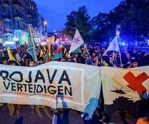 09 October 2019, Hamburg: Kurds hold a banner with the inscription "Defend Rojava" during a protest against the Turkish military offensive in Northern Syria, at Sternschanze station. Photo: Axel Heimken/dpa