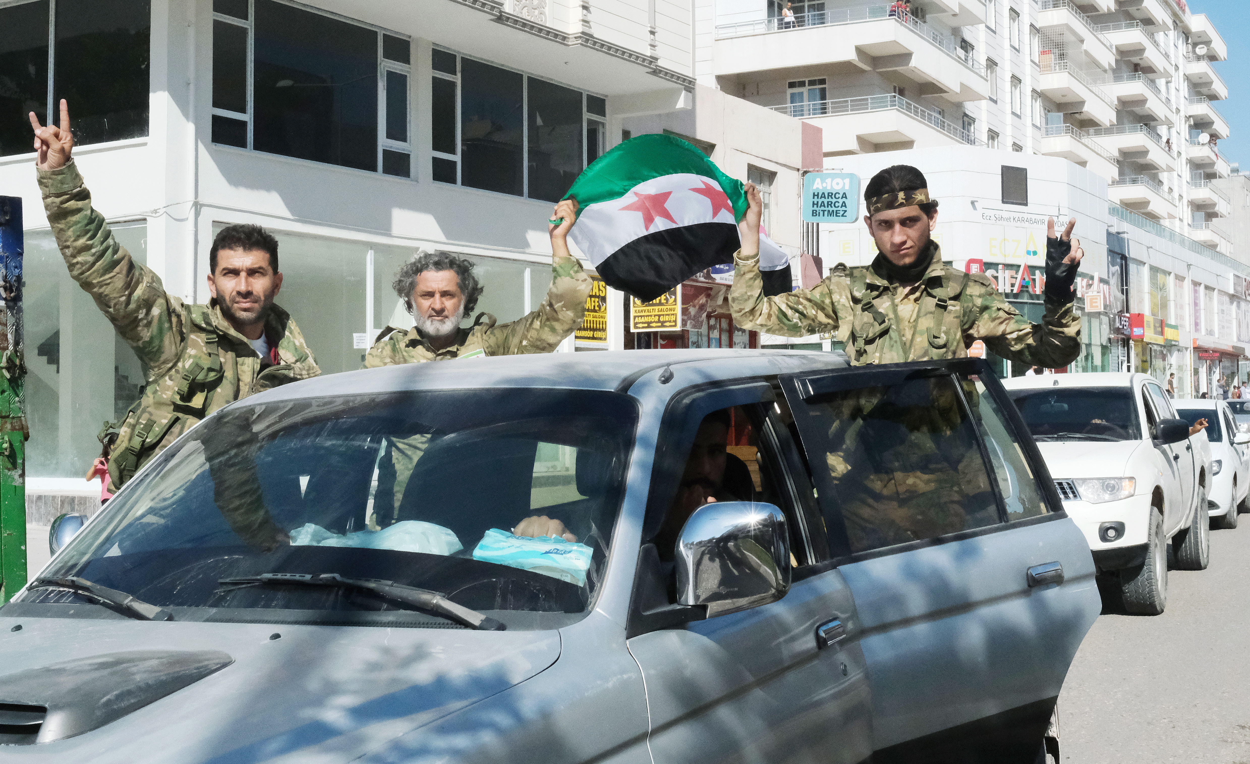 epa07909327 Members of Syrian National Army wave as they are on the way to Northern Syria for a military operation in Kurdish areas, near the Syrian border, in Akcakale, Sanliurfa, Turkey 10 October 2019. Turkey has launched an offensive targeting Kurdish forces in north-eastern Syria, days after the US withdrew troops from the region.  EPA/STR