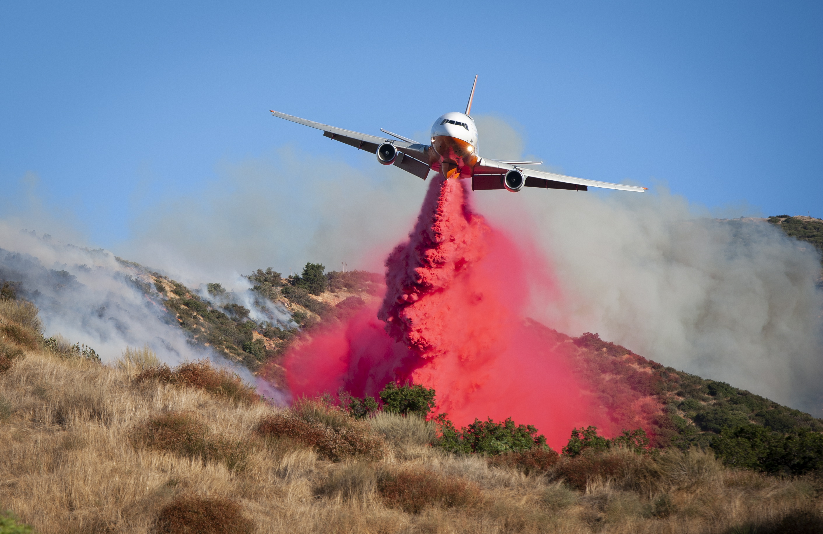 epaselect epa07913908 A large air tanker drops fire retardant on the Saddleridge Fire in Sylmar, California, USA, 11 October 2019. The fire had burned over five thousand acres as of 11 October 2019. According to the latest reports the fire is progressing quickly due to the strong winds, prompting an evacuation of the nearby inhabitants.  EPA/CHRISTIAN MONTERROSA