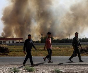 epa07917132 People walk near Turkish-Syria border as smoke rises from targets inside Syria during bombardment by Turkish forces at Tal Abyad town as seen from in Akcakale district in Sanliurfa, Turkey, 13 October 2019. Turkey has launched an offensive targeting Kurdish forces in north-eastern Syria, days after the US withdrew troops from the area.  EPA/SEDAT SUNA