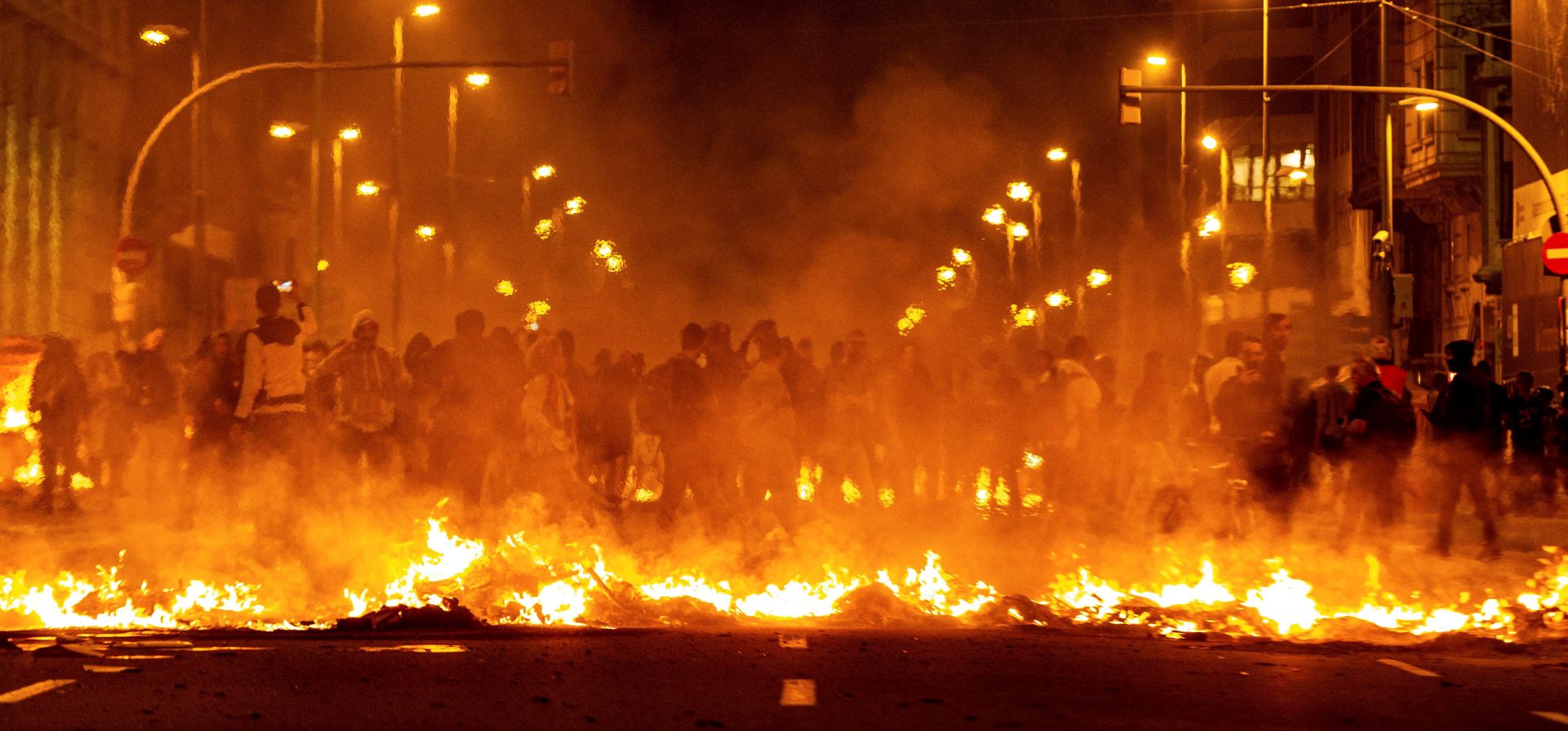 epa07923746 Protesters create a burning barricade during a rally against the sentence ruled by Supreme Court on 'proces' trial' in downtown Barcelona, Catalonia, Spain, 15 October 2019. Demonstrators are blocking some roads in Catalonia against the court's decision.The Spanish Supreme Court on 14 October 2019 issued a fresh European arrest warrant for the deposed former president following its sentencing of former Catalan Vice President Oriol Junqueras to 13 years in jail for sedition and misuse of public funds. Several other political leaders were also handed multi-year prison sentences for their roles in holding a failed independence vote in 2017.  EPA/ENRIC FONTCUBERTA