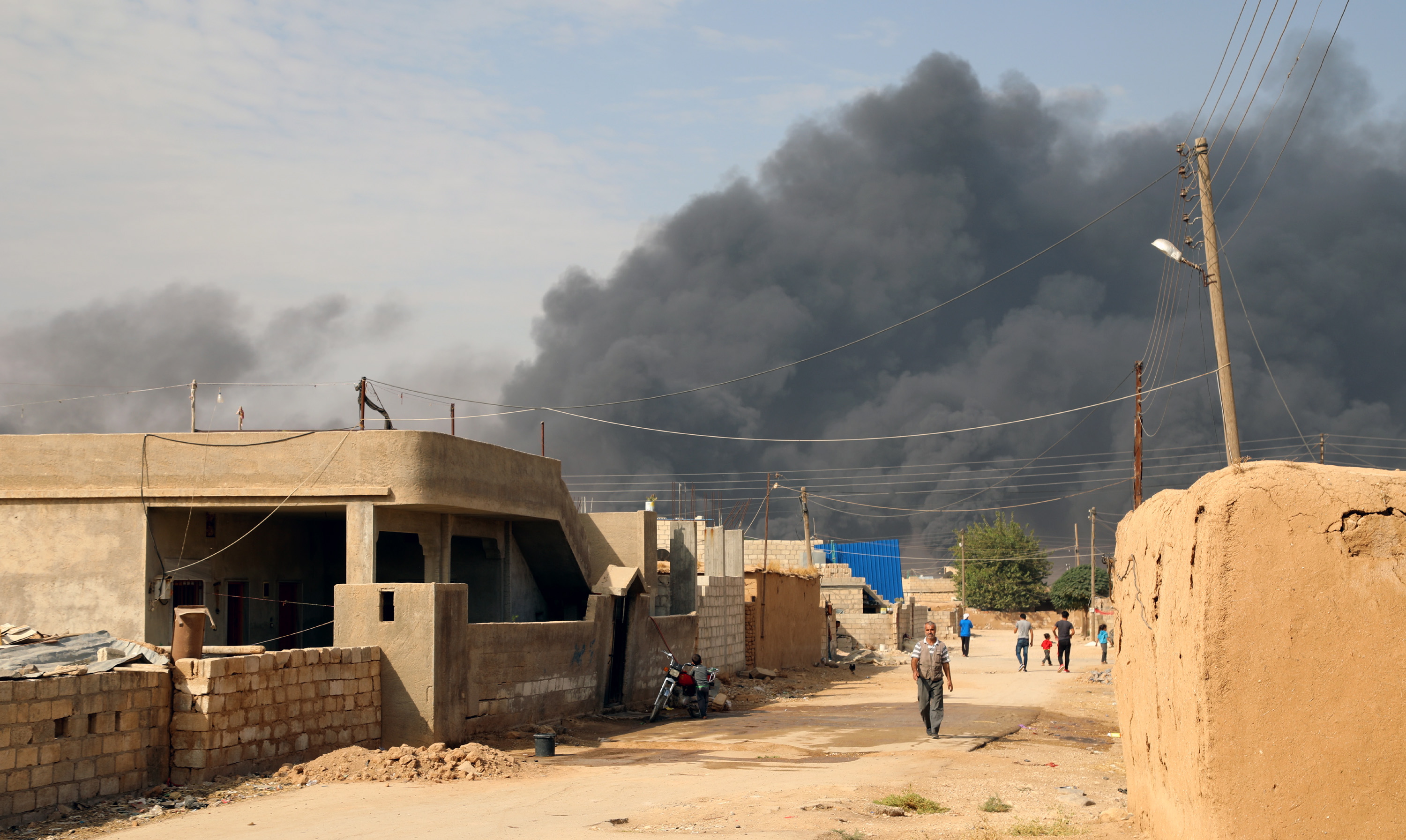 epa07927386 A general view showing smoke clouds rising from the scene of clashes between the Syria democratic forces (SDF) and Turkish troops and their Syrian opposition allies near Ras al-Ain town, northeastern of Syria on 17 October 2019. The Turkish offensive in northeastern Syria against Kurdish militants has displaced more than 300,000 people, human rights organizations said.  EPA/AHMED MARDNLI