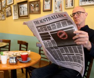 epa07937921 A man reads a copy of Australian newspaper 'The Advertiser' featuring a 'Your Right to Know' campaign illustration as part of a national media campaign, in Adelaide, Australia, 21 October 2019. The front pages of some major newspapers on 21 October replicated a heavily redacted government document, alongside an advertising campaign challenging laws that effectively criminalize journalism and whistleblowing.  EPA/KELLY BARNES  AUSTRALIA AND NEW ZEALAND OUT