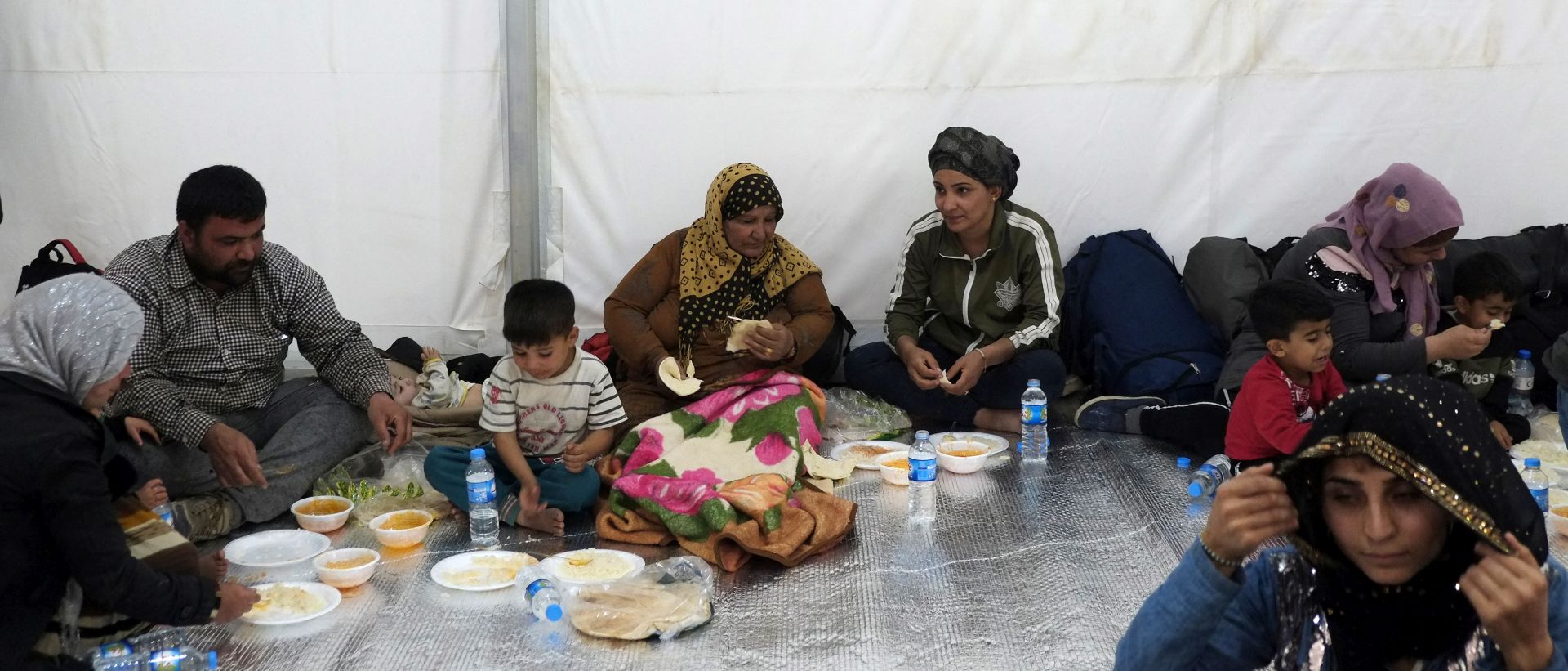 epa07938822 Syrian refugees eat after arriving at Bardarash refugee camp in South of Duhok, Kurdistan region, Iraq, 21 October 2019. According to camp officials, more than 1200 refugee arrived to the camp on 21 October after fleeing the Turkish military operation in Syria. Turkey has launched an offensive targeting Kurdish forces in north-eastern Syria on 09 October, days after the US withdrew troops from the area.  EPA/GAILAN HAJI