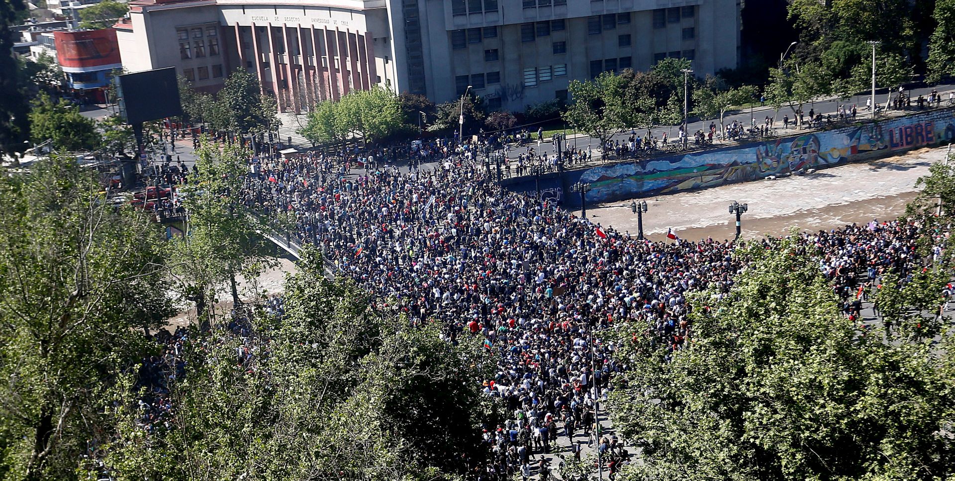 epa07939402 Demonstrators participate in a new day of mass protests at Plaza Italia, in Santiago, Chile, 21 October 2019. An unrest, sparked by a hike in metro fares, quickly morphed into a wider protest against social inequality. Chilean Army general Javier Iturriaga, responsible for security during the state of emergency decreed in Santiago, established on the same day the third curfew in the Chilean capital and the rest of the Metropolitan region due to the persistence of the riots.  EPA/Esteban Garay