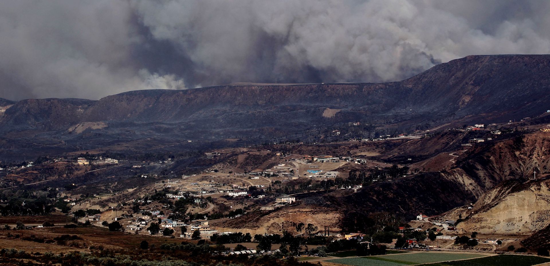 epa07950105 General view of a fire, in the city of Tijuana, Baja California, Mexico, 25 October 2019. The Mexican State of Baja California, northwestern Mexico, was impacted in the last two days by the Santa Ana weather condition, authorities said. The Santa Ana condition or Santa Ana winds are extremely dry winds that appear in the climate of southern California, the United States and northern Baja California, Mexico, during the fall and early winter.  EPA/ALEJANDRO ZEPEDA