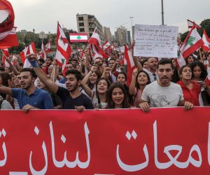 epa07951639 Lebanese students carry a banner with Arabic words reading 'universities of Lebanon uprising' as they block the main highway leading to Achrafieh on the tenth day of protest in Beirut, Lebanon, 26 October 2019. Thousands continued to protest on the second week of demonstrations against proposals of tax hikes and state corruption, and calling for the resignation of the government.  EPA/NABIL MOUNZER