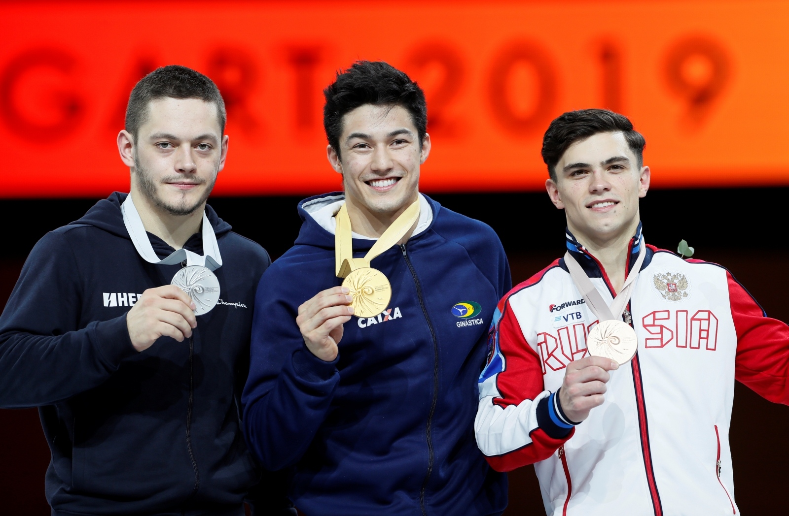 2019 World Artistic Gymnastics Championships Artistic Gymnastics - 2019 World Artistic Gymnastics Championships - Men's Horizontal Bar Final - Hanns-Martin-Schleyer-Halle, Stuttgart, Germany - October 13, 2019   Gold medalist Brazil's Arthur Mariano, silver medalist Croatia's Tin Srbic and bronze medalist Russia's Artur Dalaloyan pose as they celebrate on the podium with their medals   REUTERS/Wolfgang Rattay WOLFGANG RATTAY
