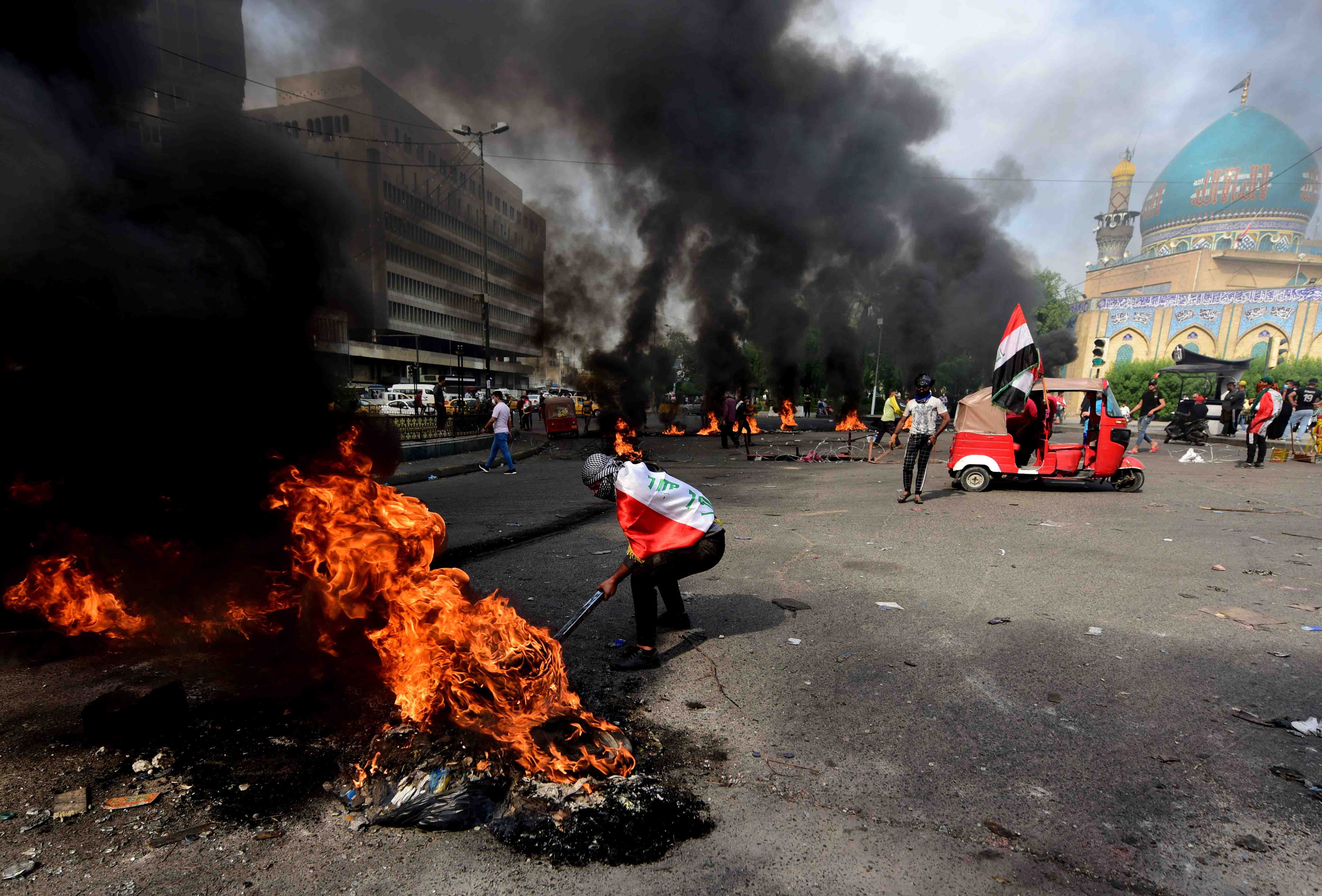 epa07969460 Iraqi protesters set fire to car tires to block a street during a protest and strike at Khillani square in central Baghdad, Iraq, 03 November 2019. Thousands of Iraqi teachers and university students participated in a strike and hundreds of protesters closed the roads in Baghdad as part of the wave of protests across the country, against the Iraqi government corruption, in response to the call of Iraqi Teachers Union and activists.  EPA/MURTAJA LATEEF